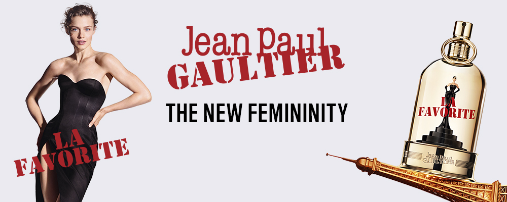 Jean Paul Gaultier La Favorite-banner med en kvinna i svart klänning och en parfymflaska. Text: ”The New Femininity”.