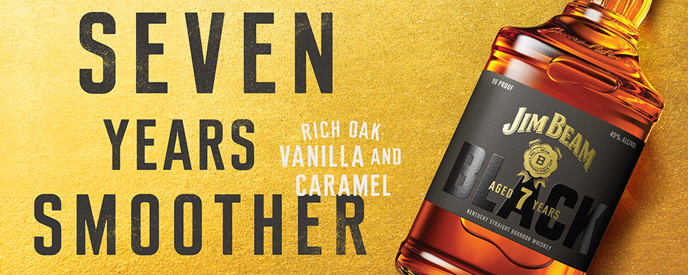 Jim Beam Black-banner med en flaske bourbon på gylden baggrund. Tekst: “Seven years smoother” og “Rich oak, vanilla and caramel”.