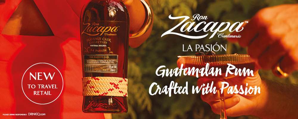 Flaska Ron Zacapa La Pasión och ett glas rom i handen i en reklambild med texten 'Guatemalan Rum Crafted with Passion'.