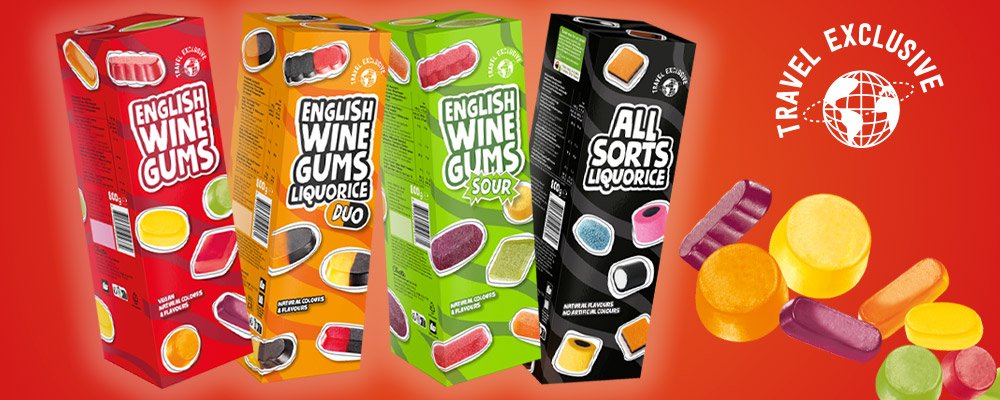 Banner med fyra färgglada förpackningar av English Wine Gums och All Sorts Liquorice samt olika godisbitar mot röd bakgrund. Text: ”Travel Exclusive”.